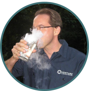 Glen with a dry ice infused drink wearing an Aperture Labs work-shirt.